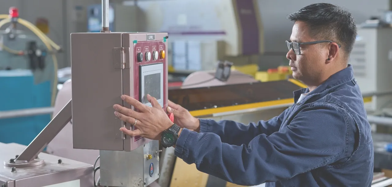 An Express technician at the control panel of a production machine on the San Diego factory floor.