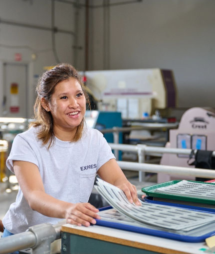 A member of the Express production team sorting sheets of freshly printed labels.
